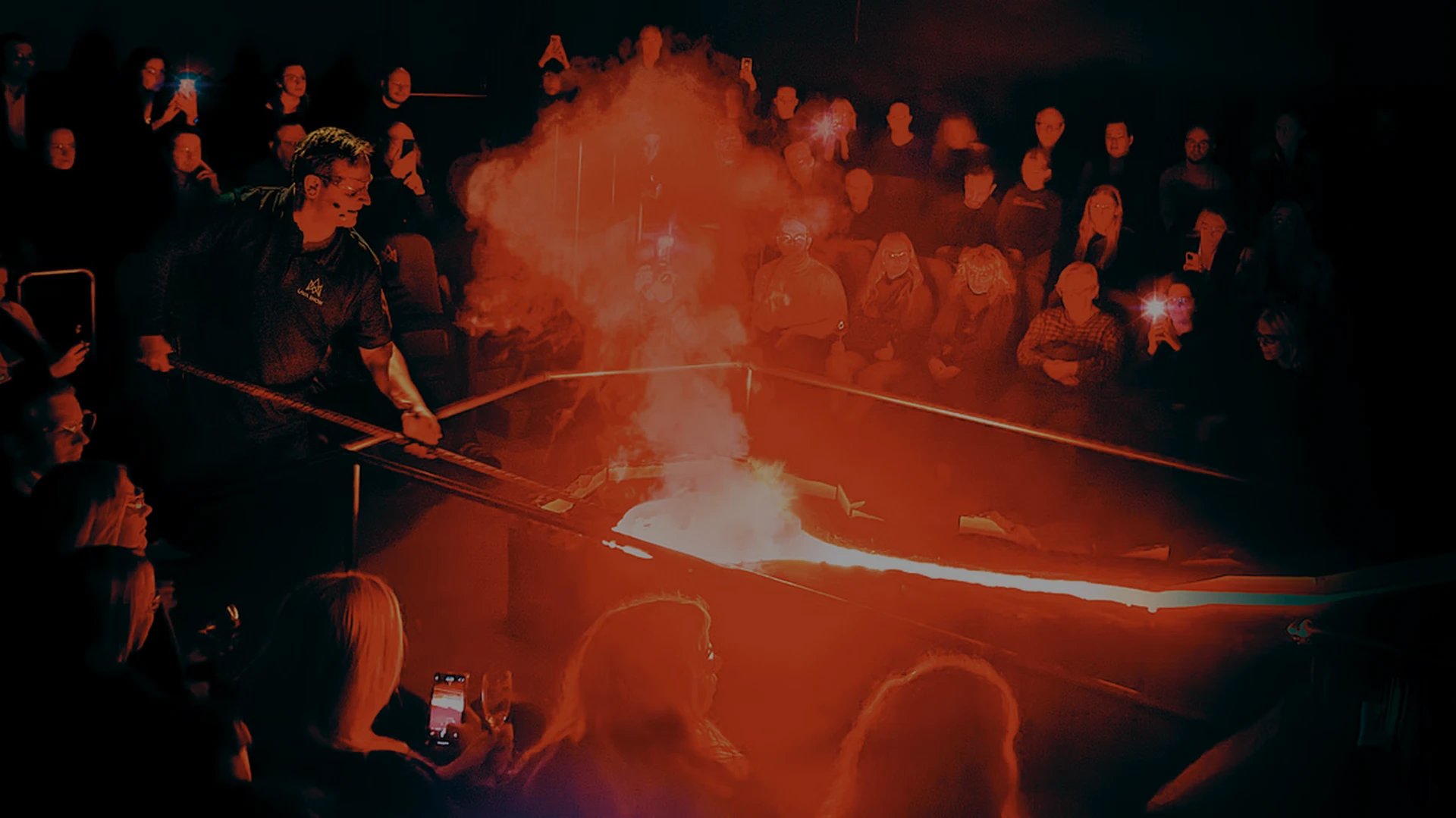 Audience watching mesmerizing lava flow demonstration indoors