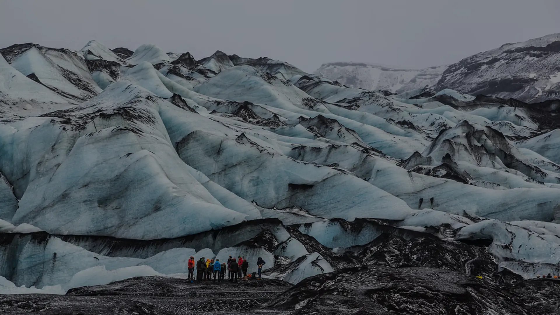 Group of glacier hikers walking on Sólheimajökull with guide