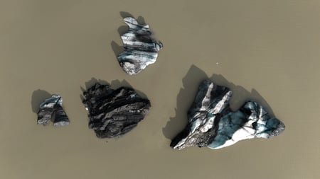 Icebergs reflecting in the water of the glacier lake of Sólheimajökull