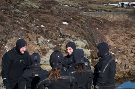 Clients are listening to their diving instructor before snorkeling in Silfra