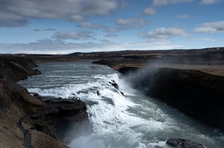 The immense Gullfoss waterfall with people by its side