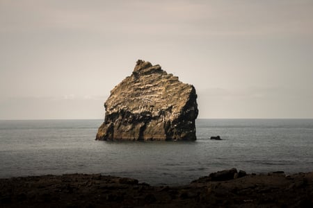 Lone rock offshore visible from the Reykjanes Peninsula by Reykjanesviti