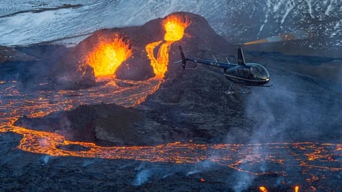 Helicopter flying over active volcanic eruption site