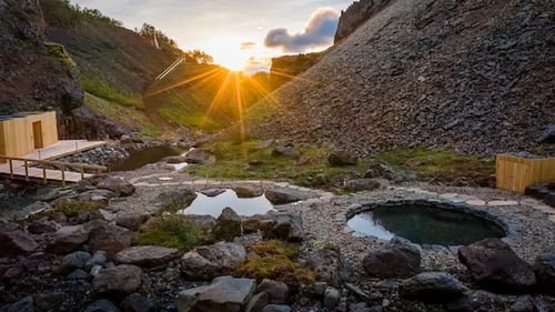 Húsafell Canyon Baths nestled in dramatic canyon landscape