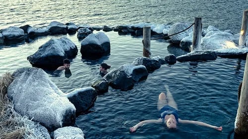 Hvammsvík Hot Springs with ocean and mountain backdrop