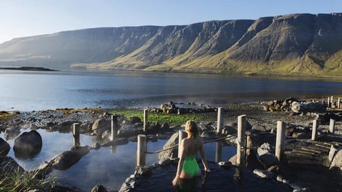 Hvammsvík Hot Springs with ocean and mountain backdrop