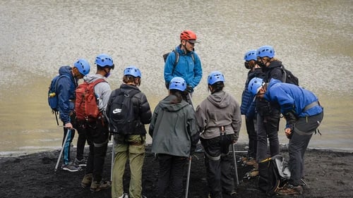 Small group of hikers exploring Sólheimajökull glacier ice formations