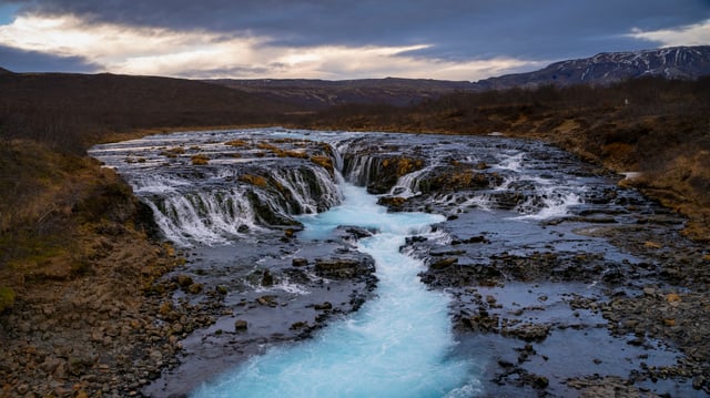 A beautiful waterfall is falling in a turquoise blue river