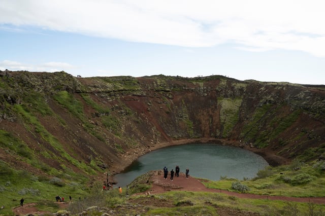 A red volcanic crater with a lake at its bottom