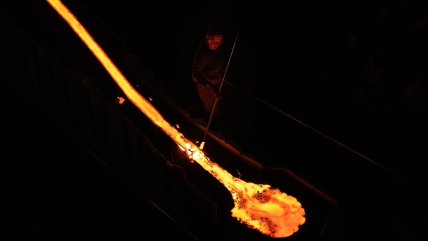 A stream of lava is flowing down in a dark room during the Lava Show