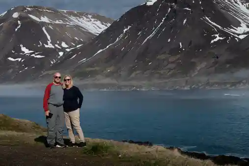 People smiling in front of an icelandic fjord
