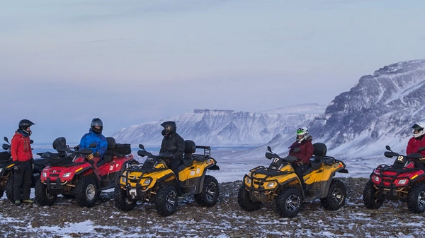 ATV riders on scenic lakeside trail near Lake Hafravatn