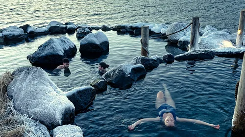 Hvammsvík Hot Springs with ocean and mountain backdrop