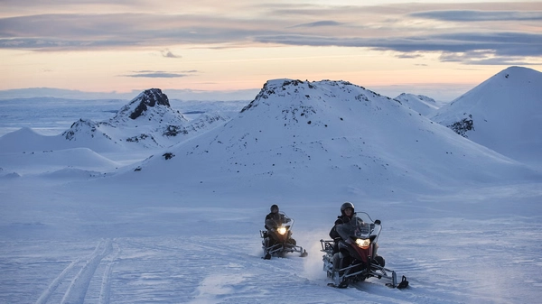 Snowmobile rider in action on Langjökull with snow spray