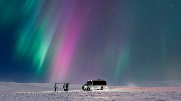 Vibrant green and purple aurora borealis dancing across the Arctic sky