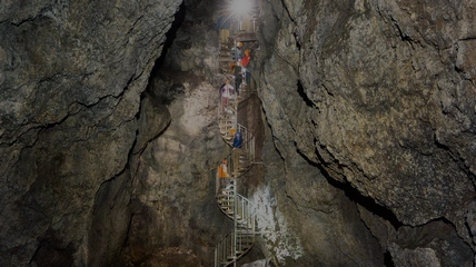 Inside Vatnshellir cave showing dramatic lava tube formations and lighting