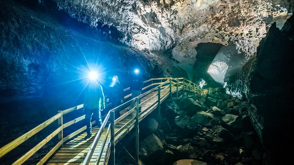 Professional geologist guide explaining volcanic processes in underground chamber