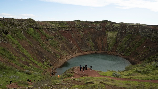 A red volcanic crater with a lake at its bottom