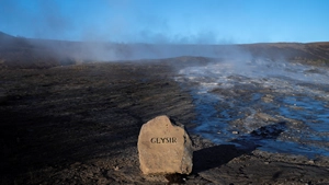 Stone before a hot spring with the name Geysir engraved in it