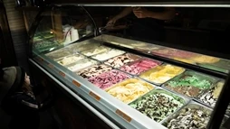 Little kid before an apetizing display of home made ice cream in Efstidalur