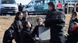 Clients are listening to their diving instructor before snorkeling in Silfra
