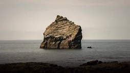 Lone rock offshore visible from the Reykjanes Peninsula by Reykjanesviti