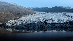 An icelandic glacier during a peaceful day, reflecting on calm waters
